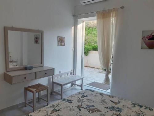 Cette chambre blanche dispose d'un miroir, d'une commode et d'une fenêtre. dans l'établissement Renovated apartment in Adelianos Kampos, à Adelianos Kampos