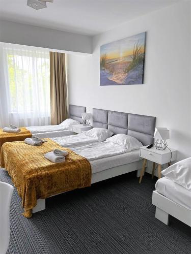 a hotel room with two beds and a large bed at Apartamenty Planeta Mielno in Mielno