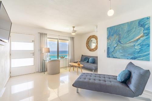 a living room with a couch and a view of the ocean at Ocean View Three Bedroom, Three Story Penthouse by the Beach in Cancún