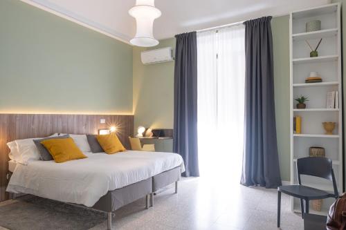 a bedroom with a large bed with yellow pillows at Àita Domus in Catania