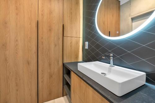 a bathroom with a white sink and a mirror at Luxury Copper Apartment in Łódź