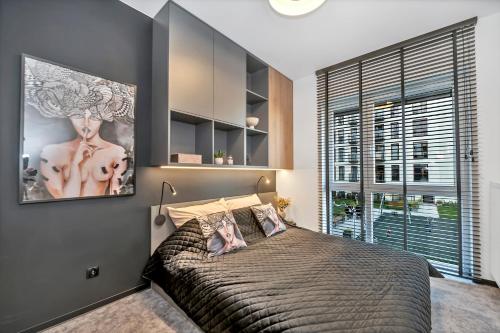 sypialnia z dużym łóżkiem i dużym oknem w obiekcie Luxury Copper Apartment w Łodzi