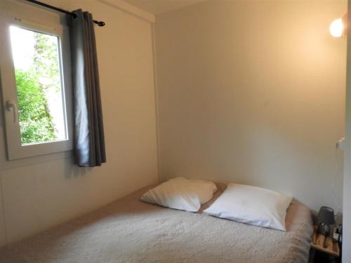 a bed in a room with a window at Village 17 gites, Piscine, Restaurant , 2 gites avec SPA, 3km de Conques in Conques