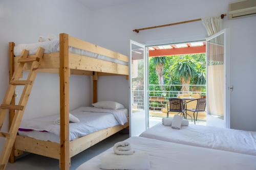 a bedroom with two bunk beds and a balcony at Wilde Rose Hotel in Dassia