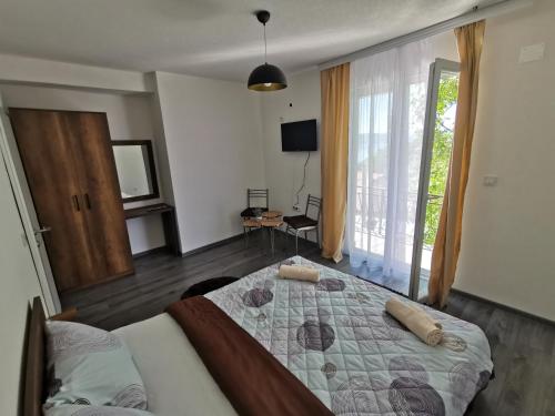um quarto com uma cama e uma grande janela em GOPO Guesthouse Elshani em Ohrid