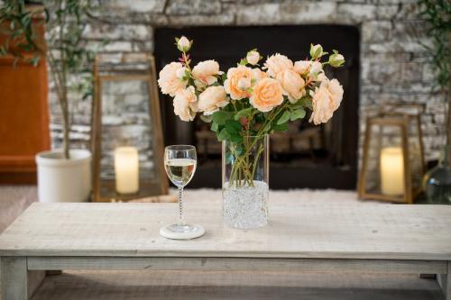 a vase of flowers and a glass of wine on a table at Luxe Quiet Townhouse w/Parking/Pool/By Dollywood in Pigeon Forge