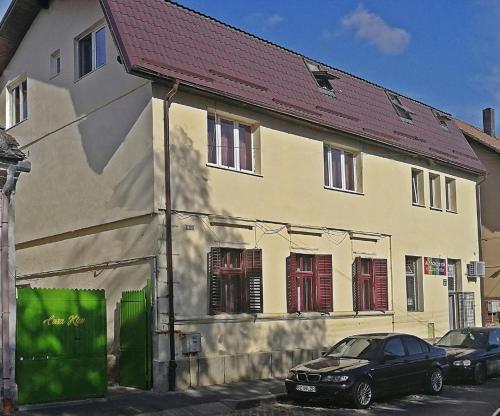 ein Auto, das vor einem Gebäude mit roten Rollläden parkt in der Unterkunft Casa Kiev in Sibiu