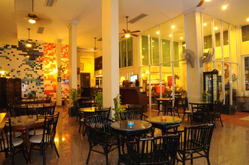 um restaurante com mesas e cadeiras num quarto em Lodge 61 Hotel em Banguecoque