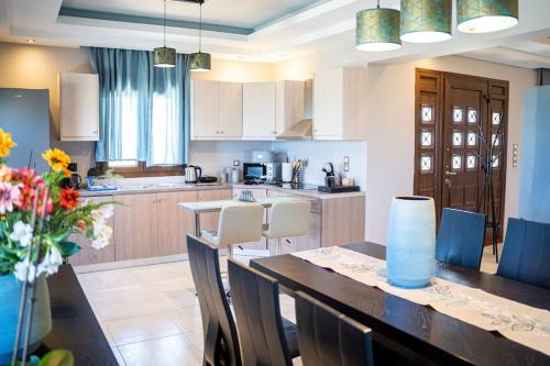 a kitchen with a table and chairs and a kitchen with a counter at Luxury Apartments in Platánion
