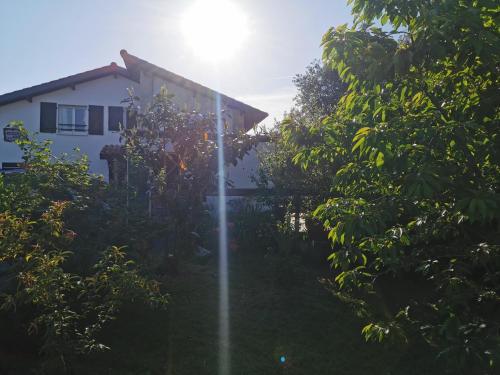 a house with the sun shining through the trees at GÎTE AZKENDANTZA 2a6 PERS AVEC CARAVANE INSOLITE in Ascain
