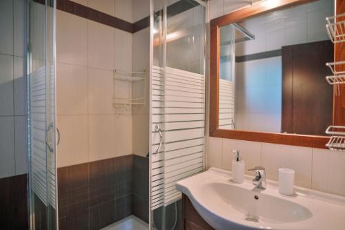 a bathroom with a sink and a shower and a mirror at Villa Aiolos in Alexandroupoli