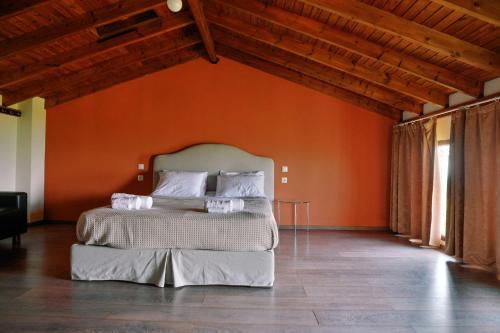 a bedroom with a bed with an orange wall at Villa Aiolos in Alexandroupoli