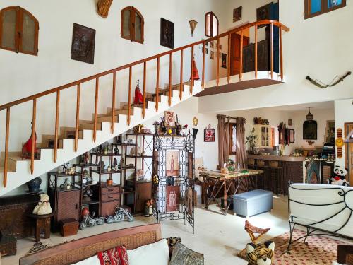 a living room with a spiral staircase in a house at Fabuleuse Villa Keur Bibou in Dakar