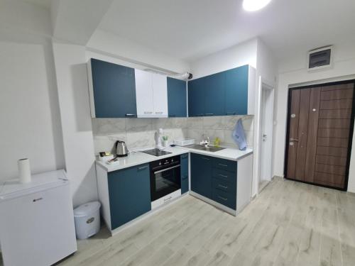a kitchen with blue cabinets and white counters at Happy apartments Strumica in Strumica