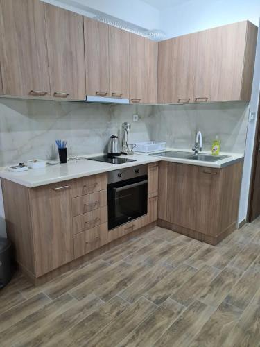 a kitchen with wooden cabinets and a sink and a stove at Happy apartments Strumica in Strumica