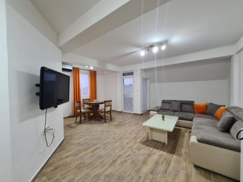 a living room with a couch and a tv at Happy apartments Strumica in Strumica