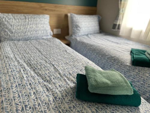 ペイントンにあるHoburne Devon Bay - Hot Tub 2 Bed Paigntonのベッドルーム1室(ベッド2台、緑のタオル付)