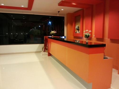 a red and orange kitchen with a long counter at Perfect Place Hotel in Surat Thani