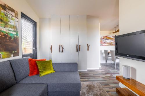 a living room with a couch and a flat screen tv at Buiten Huisje aan de Vaart 2 in Matsloot