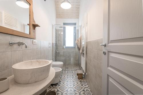 a bathroom with a tub and a toilet and a sink at Borgo Altobello in Cisternino