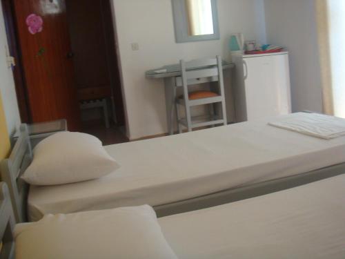 a small room with a bed and a refrigerator at Omiros in Faliraki