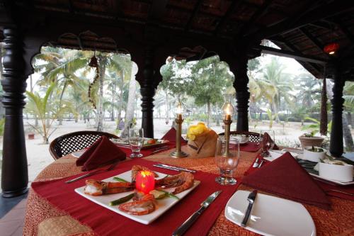 un tavolo con un piatto di cibo sopra di Amritara A Beach Symphony a Mararikulam