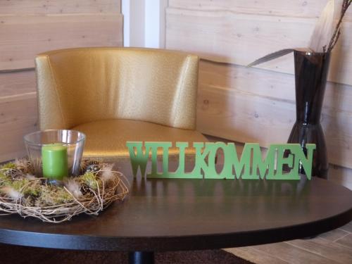 a table with a chair with a candle and a vase at Hotel Friesische Wehde in Bockhorn