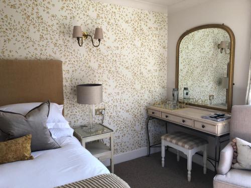a bedroom with a bed and a dressing table and a mirror at The Old Mill in Lymington