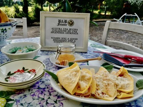 a table with a plate of food on it at B&B FETONTE in Crespino