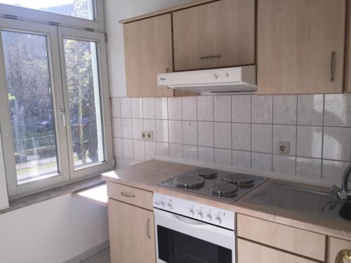 een keuken met een fornuis top oven naast een raam bij Zentrales Apartment -Am Stadtpark- in Lutherstadt Wittenberg