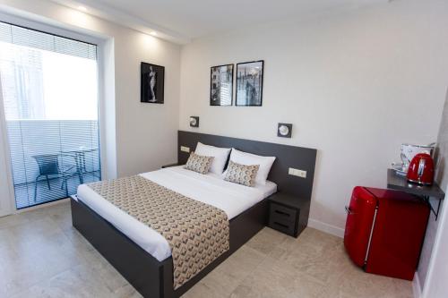 a bedroom with a bed and a red suitcase at Batumi Premiums Apartments Betta in Batumi