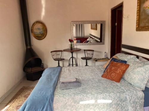 1 dormitorio con 1 cama y 1 mesa con sillas en Recanto das Orquideas, en Quatis