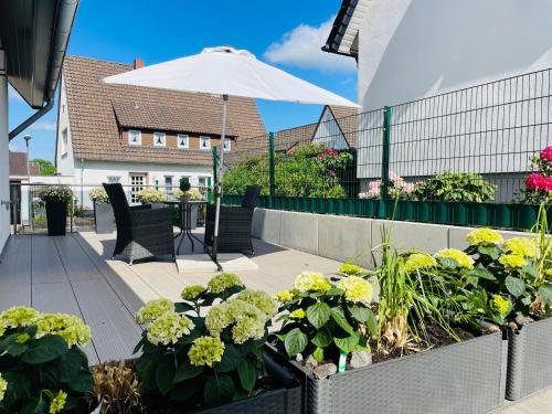 a garden with flowers and an umbrella on a patio at OD Ferienwohnung in Bad Salzuflen