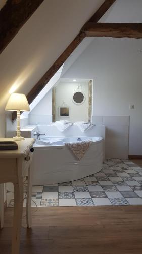 a bathroom with a white tub in a attic at Manoir de Pierreville in Audouville-la-Hubert