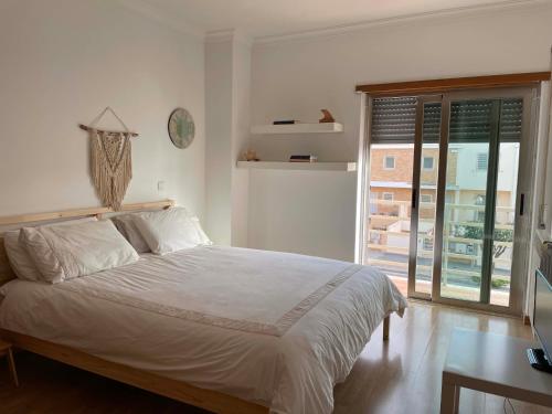 a bedroom with a bed and a large window at casa da praia azul in Torres Vedras