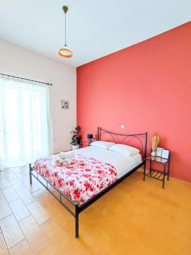 a bedroom with a bed with a red wall at Sette Isole Countryside Retreat Near Egremni Beach in Athanion