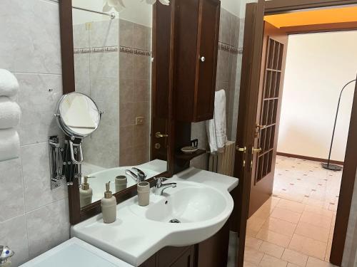 ストレーザにあるAppartamento miralagoのバスルーム(白い洗面台、鏡付)