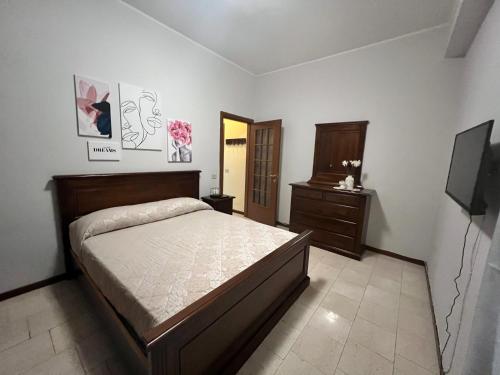 1 dormitorio con 1 cama, vestidor y TV en Appartamento miralago, en Stresa
