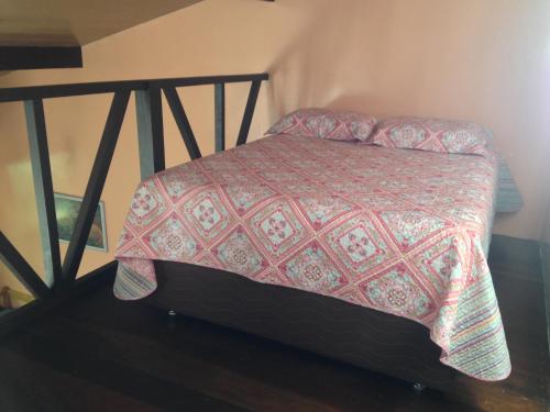 1 dormitorio con 1 cama con edredón rojo en Chalé Verde - Vale do Capão, en Vale do Capao