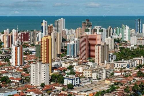 Une grande ville avec de grands bâtiments et l'océan dans l'établissement Quarto Individual para 3 Pessoas em AP Compartilhado, à João Pessoa