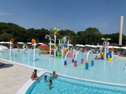 un gruppo di persone in una piscina in un parco acquatico di Villa Amedea a Lignano Sabbiadoro