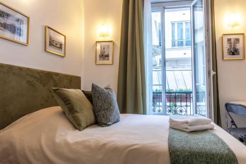 パリにあるMontmartre Apartments Chagallのベッドルーム1室(ベッド1台、大きな窓付)