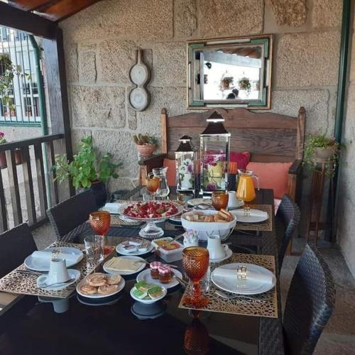 a table with plates and bowls of food on it at Casa do Adro de Parada in Parada de Pinhão