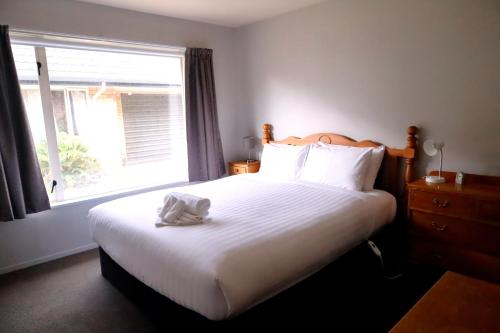 a bedroom with a large white bed with a window at Location Ocean & Mountain Views Close to Park in Kaikoura