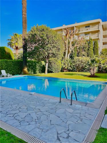 une piscine devant un immeuble dans l'établissement STUDIO PALM BEACH CANNES, à Cannes