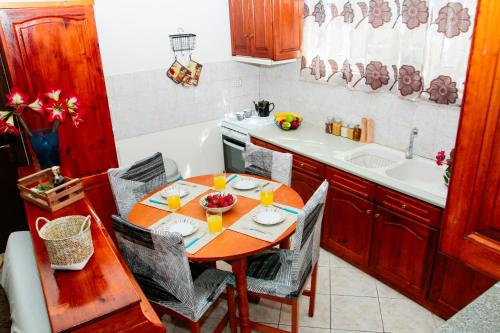 cocina con mesa de madera, sillas y fregadero en Sette Isole Countryside Apartment en Athánion