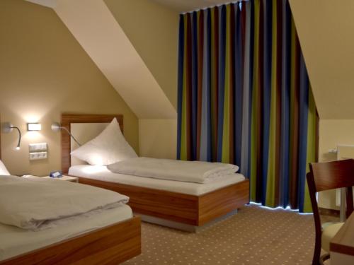 a hotel room with two beds and a window at Hotel Friesische Wehde in Bockhorn