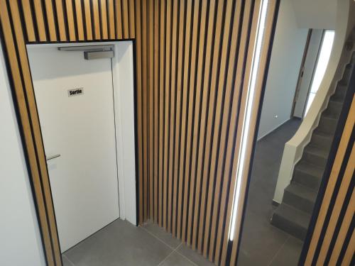 a white elevator in a hallway next to a staircase at Guesthaus 2 in Dudelange