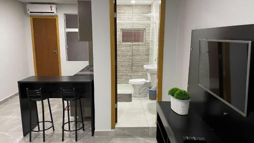 a bathroom with a black counter and a sink and a toilet at Novo apartamento Studio a poucos passos do Paraguai - Vila Portes in Foz do Iguaçu