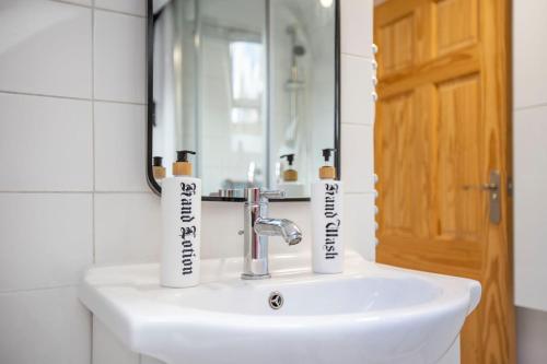 ein Waschbecken mit zwei Zahnbürsten drauf in der Unterkunft Stunning character 2bed Cottage in St Albans Wifi in St Albans